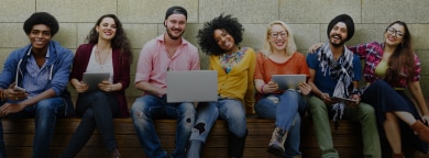 Young adults sitting together using laptops and tablets, casual setting