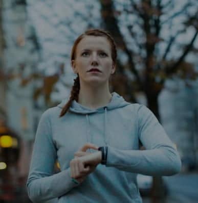 An woman running with a connected watch