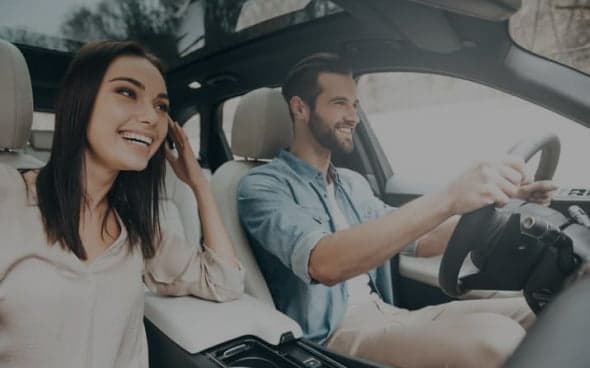 Two people driving in a car with a modern interior.