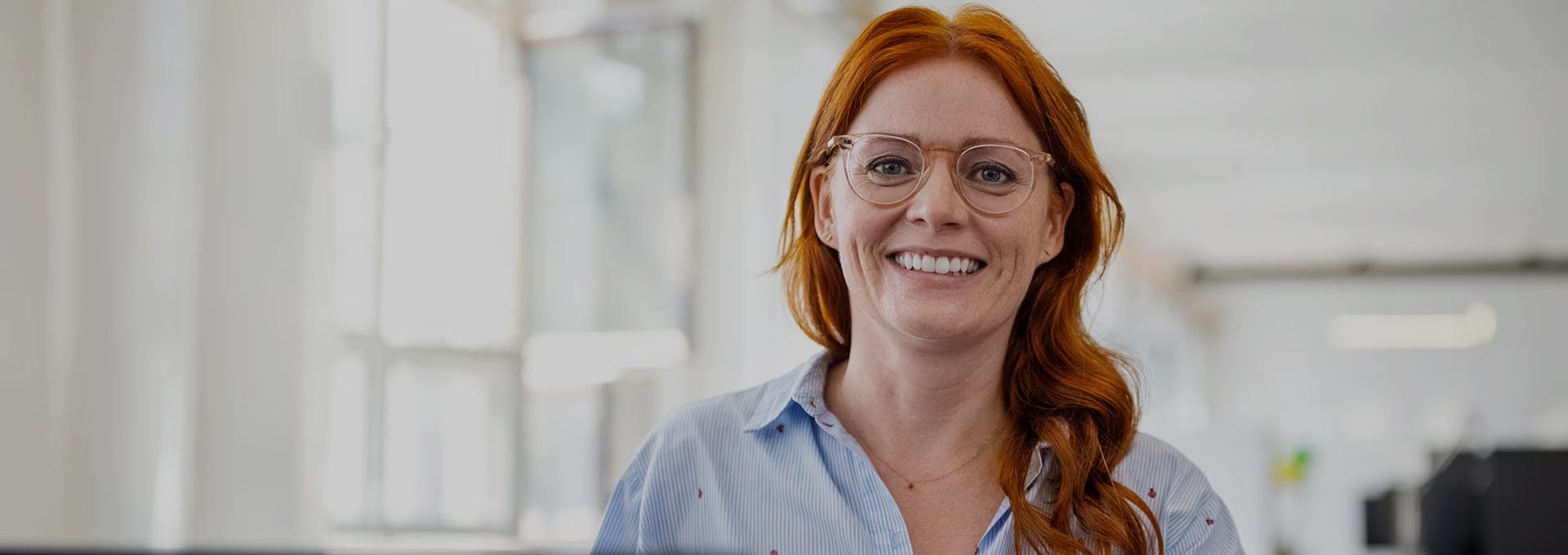 redhair woman her desk smiling