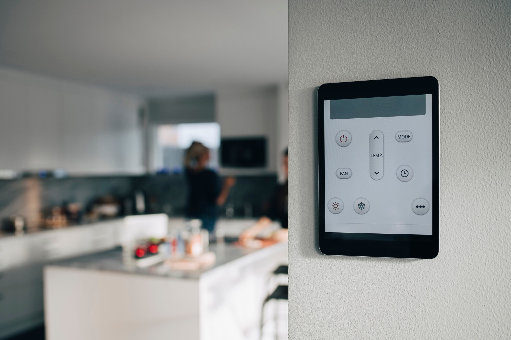 Thermostat app on digital tablet mounted over white wall at home