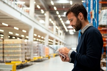 Man in a warehouse looking at a tablet