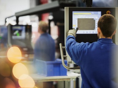 workers in steel factory using control panels